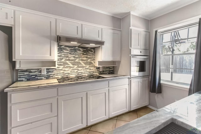 2104 Mccann Rd, Longview, TX 75601 - kitchen featuring stainless steel oven, under cabinet range hood, tasteful backsplash, stovetop, and crown molding