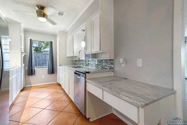 2104 Mccann Rd, Longview, TX 75601 - kitchen with appliances with stainless steel finishes, white cabinets, ceiling fan, tasteful backsplash, and light tile patterned flooring