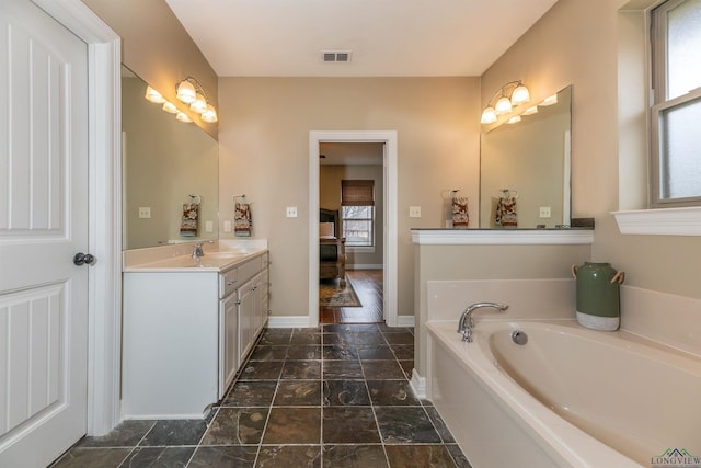 bathroom with vanity and a tub