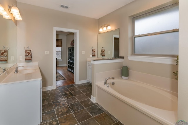 bathroom featuring vanity and a tub