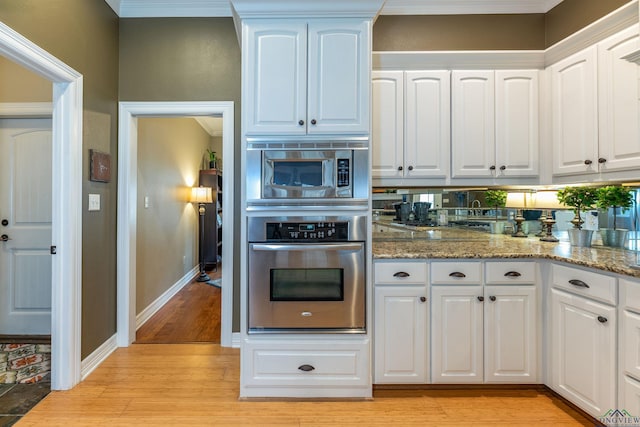 kitchen featuring white cabinetry, light stone countertops, and appliances with stainless steel finishes