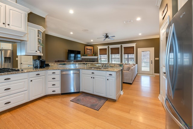 kitchen featuring sink, stone countertops, appliances with stainless steel finishes, kitchen peninsula, and white cabinets