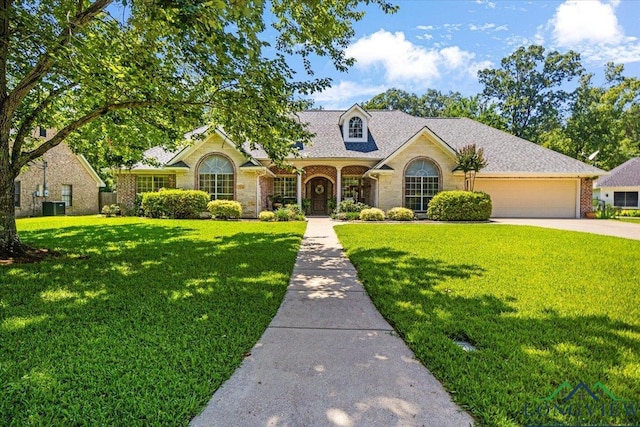 909 University Dr, Carthage, TX 75633 - view of front of property with a garage, a front lawn, stone siding, and driveway