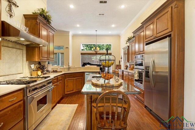 909 University Dr, Carthage, TX 75633 - kitchen with stainless steel appliances, dark wood-style floors, brown cabinetry, crown molding, and recessed lighting