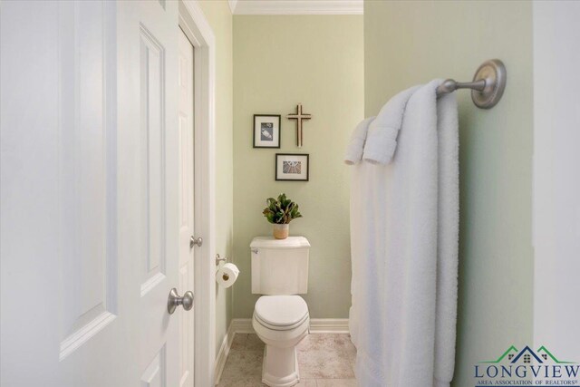 909 University Dr, Carthage, TX 75633 - bathroom with toilet, baseboards, tile patterned flooring, and ornamental molding