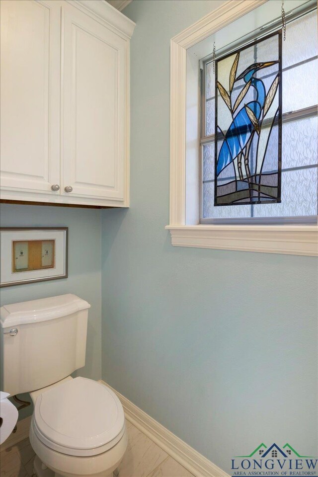 909 University Dr, Carthage, TX 75633 - bathroom with baseboards and toilet