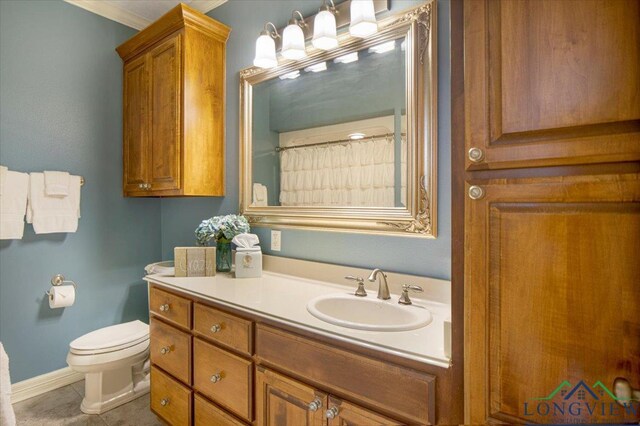 909 University Dr, Carthage, TX 75633 - full bath featuring vanity, toilet, ornamental molding, tile patterned floors, and baseboards