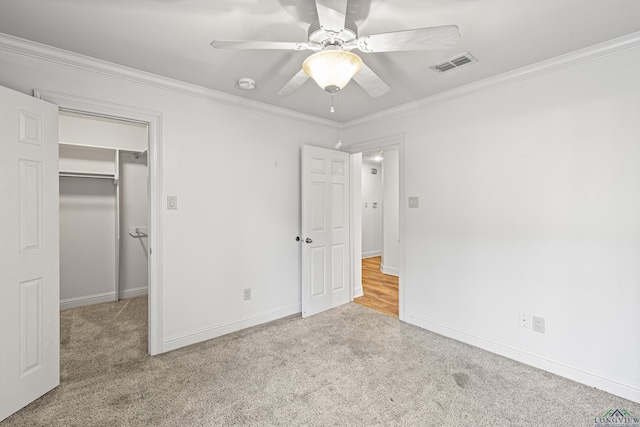 unfurnished bedroom with light carpet, ceiling fan, crown molding, and a closet