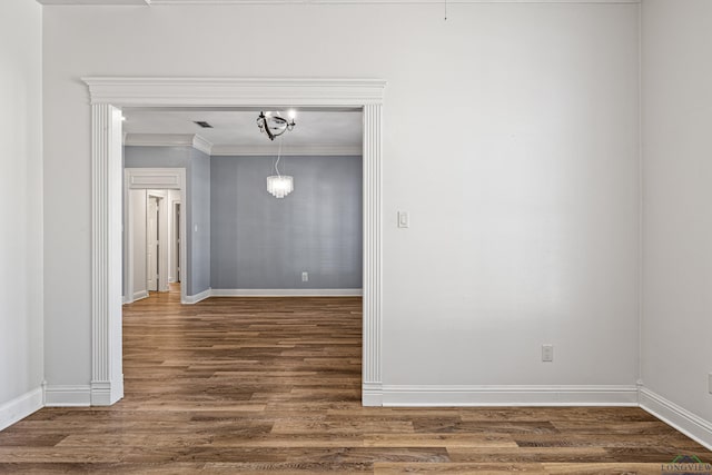 spare room featuring dark hardwood / wood-style floors and crown molding