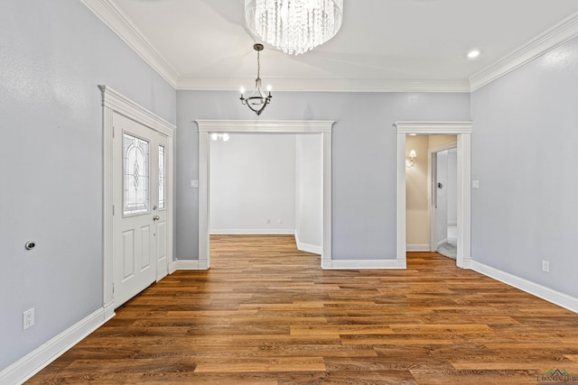 foyer entrance with crown molding, a chandelier, and hardwood / wood-style flooring