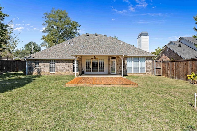 back of property featuring ceiling fan and a lawn