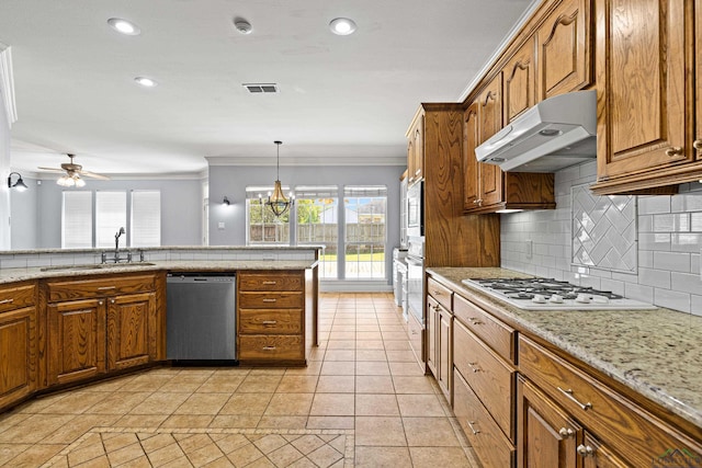 kitchen with appliances with stainless steel finishes, backsplash, crown molding, ceiling fan with notable chandelier, and sink