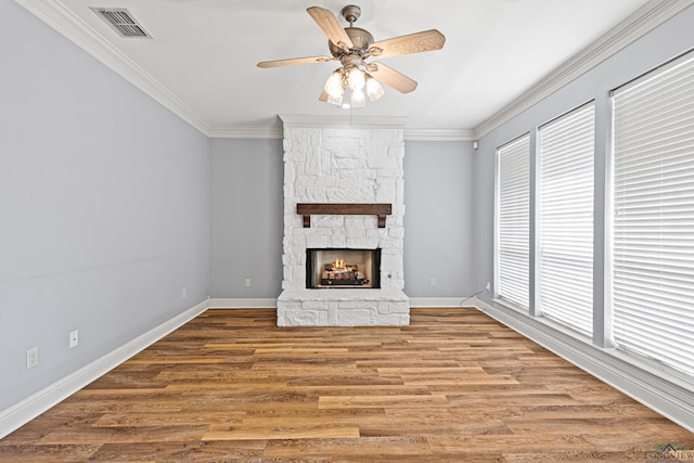 unfurnished living room featuring ceiling fan, hardwood / wood-style flooring, crown molding, and a fireplace