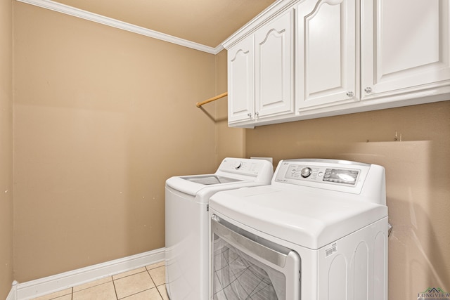 clothes washing area featuring cabinets, light tile patterned floors, ornamental molding, and washing machine and dryer