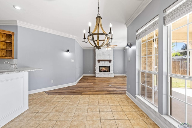 unfurnished living room featuring crown molding, a stone fireplace, and a healthy amount of sunlight