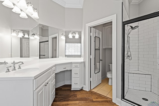 bathroom featuring toilet, a shower with shower door, tile patterned flooring, ornamental molding, and vanity