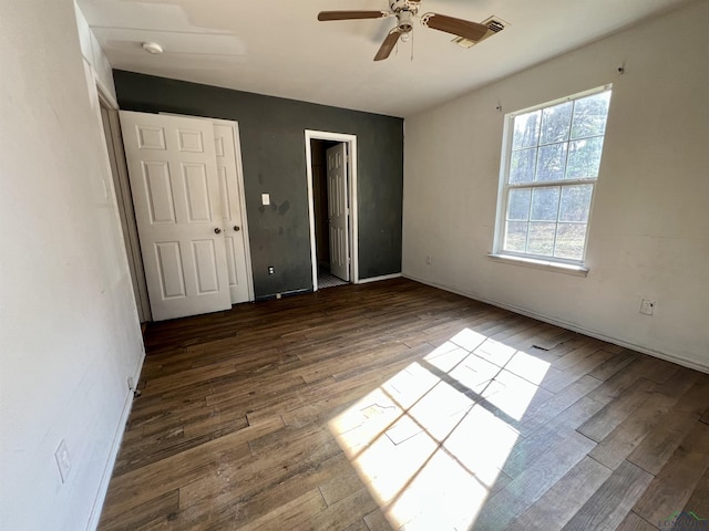 unfurnished bedroom featuring dark hardwood / wood-style floors and ceiling fan