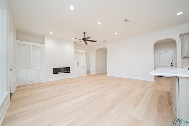 unfurnished living room with light hardwood / wood-style flooring and ceiling fan