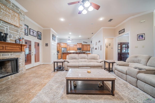 tiled living room featuring a fireplace, crown molding, and french doors