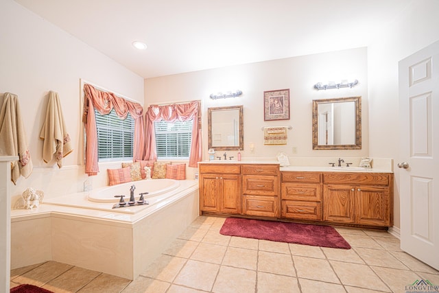 bathroom featuring tile patterned flooring, a relaxing tiled tub, and vanity