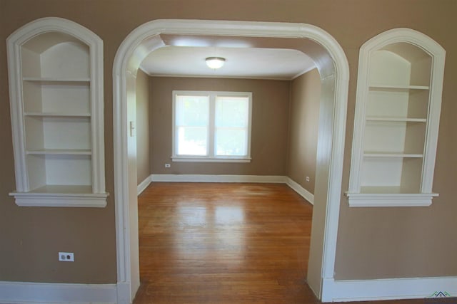 unfurnished dining area featuring light hardwood / wood-style flooring and built in shelves