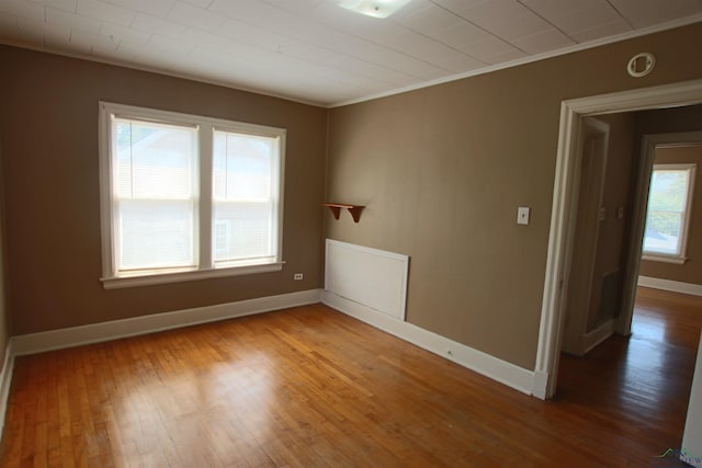 unfurnished room featuring crown molding and wood-type flooring