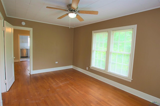 empty room with hardwood / wood-style floors, ornamental molding, and ceiling fan