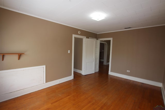 spare room with crown molding and wood-type flooring