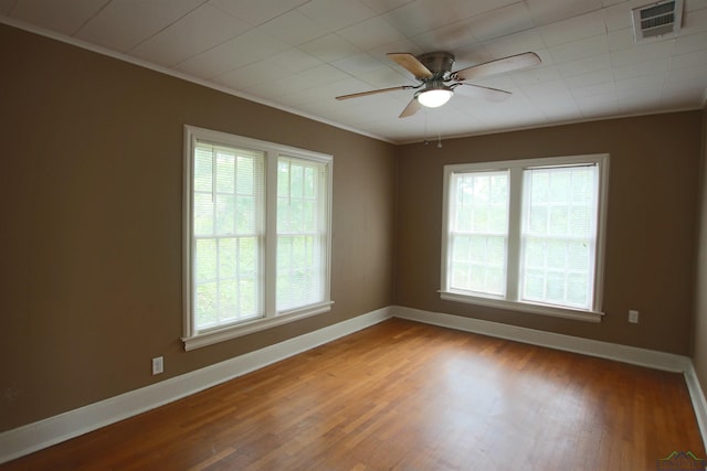 unfurnished room featuring ornamental molding, plenty of natural light, and hardwood / wood-style floors