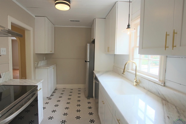 kitchen featuring pendant lighting, stainless steel appliances, sink, and white cabinets