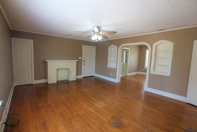 unfurnished living room with hardwood / wood-style floors, built in shelves, ornamental molding, and ceiling fan