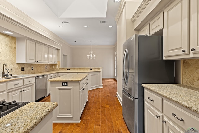 kitchen featuring appliances with stainless steel finishes, visible vents, a sink, and a peninsula