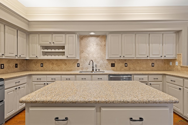 kitchen featuring a kitchen island, a sink, ornamental molding, stainless steel dishwasher, and backsplash