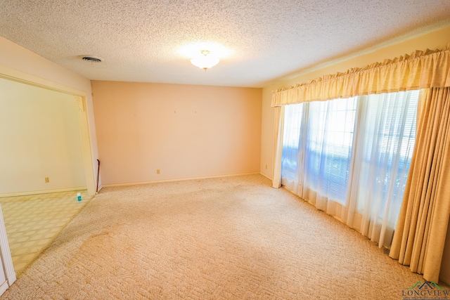 unfurnished room featuring carpet and a textured ceiling