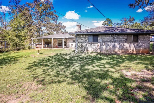 rear view of property with a yard