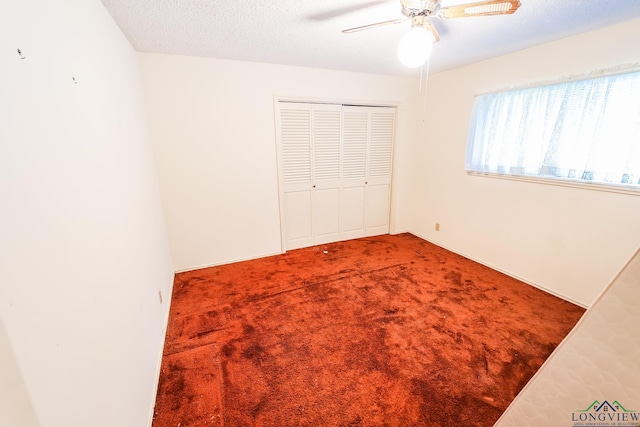 unfurnished bedroom featuring carpet flooring, ceiling fan, and a textured ceiling