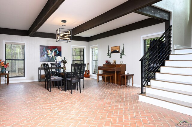 dining area featuring beam ceiling and a notable chandelier