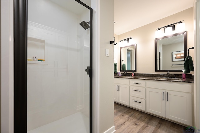 bathroom featuring hardwood / wood-style flooring, vanity, and walk in shower