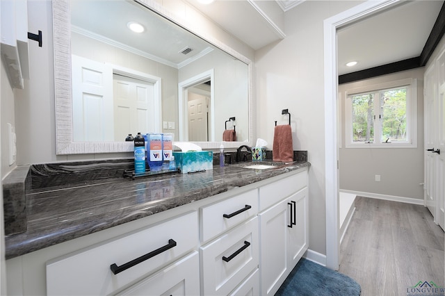 bathroom with hardwood / wood-style floors, vanity, and ornamental molding