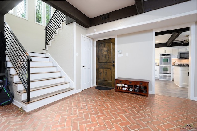 staircase with beamed ceiling