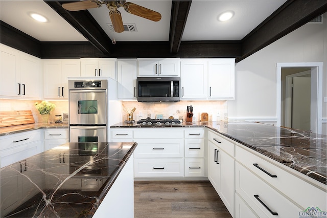 kitchen featuring tasteful backsplash, beamed ceiling, dark hardwood / wood-style flooring, white cabinetry, and stainless steel appliances