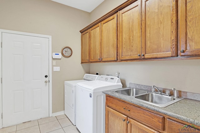 clothes washing area with sink, cabinets, separate washer and dryer, and light tile patterned floors