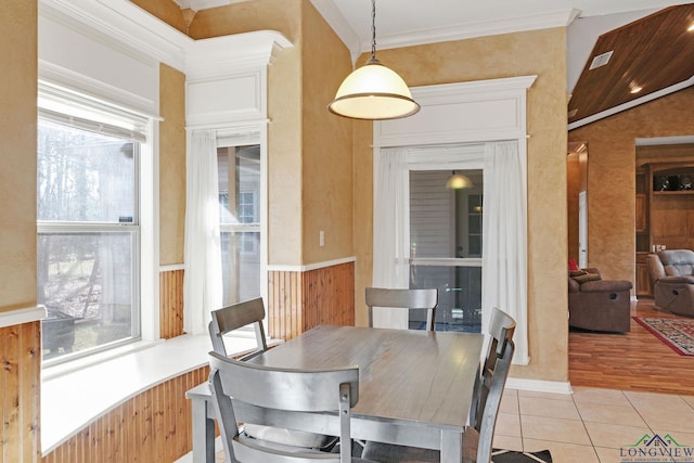 tiled dining space with crown molding and a healthy amount of sunlight