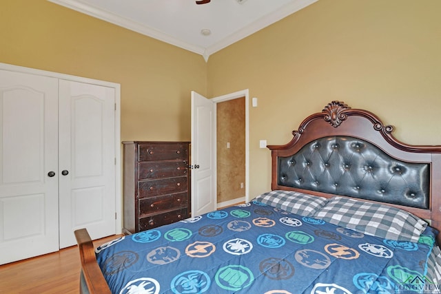 bedroom featuring ceiling fan, ornamental molding, a closet, and hardwood / wood-style floors