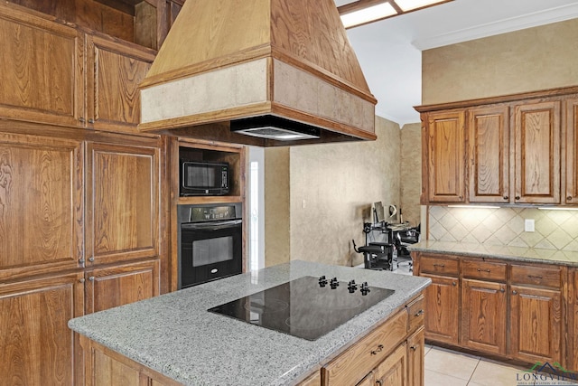 kitchen featuring backsplash, custom exhaust hood, black appliances, and light stone counters