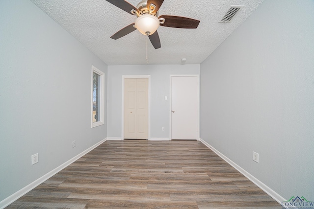 unfurnished bedroom featuring a textured ceiling, ceiling fan, a closet, and wood-type flooring