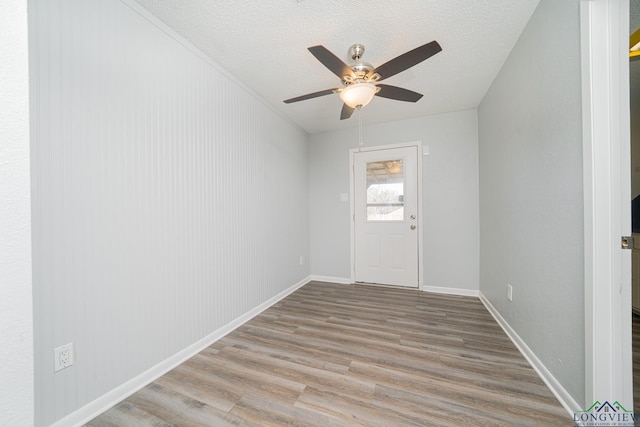 unfurnished room with ceiling fan, a textured ceiling, and light hardwood / wood-style flooring