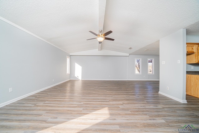 unfurnished living room featuring light wood-type flooring, ceiling fan, lofted ceiling, and a textured ceiling