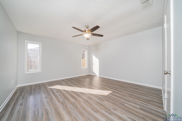 spare room with ceiling fan, a textured ceiling, and hardwood / wood-style flooring