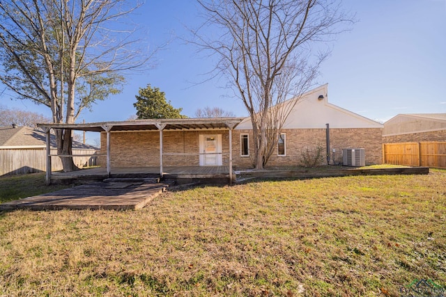 back of property featuring central air condition unit and a yard